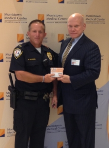 Morristown Police Lt. Matt Rawding (L) holds a case of Narcan, a life-saving medication for heroin overdoses, with the Atlantic Health System’s Director of Protection and Security Services, Alan Robinson (R). Morristown Medical Center donated the medicine to the police. Photo courtesy of Morristown Medical Center.