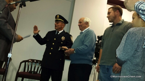 Matt Rawding, a father of seven, is sworn in as a police lieutenant. His father holds Bible. Photo by Kevin Coughlin